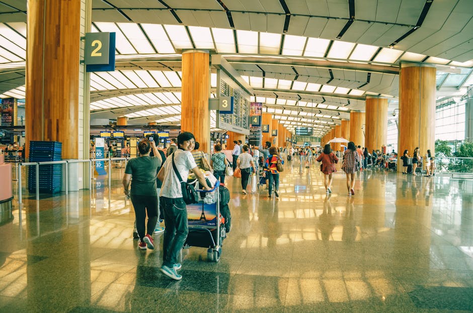 Travelers bustling through Singapore Changi Airport terminal, highlighting the dynamic and vibrant atmosphere of international travel.